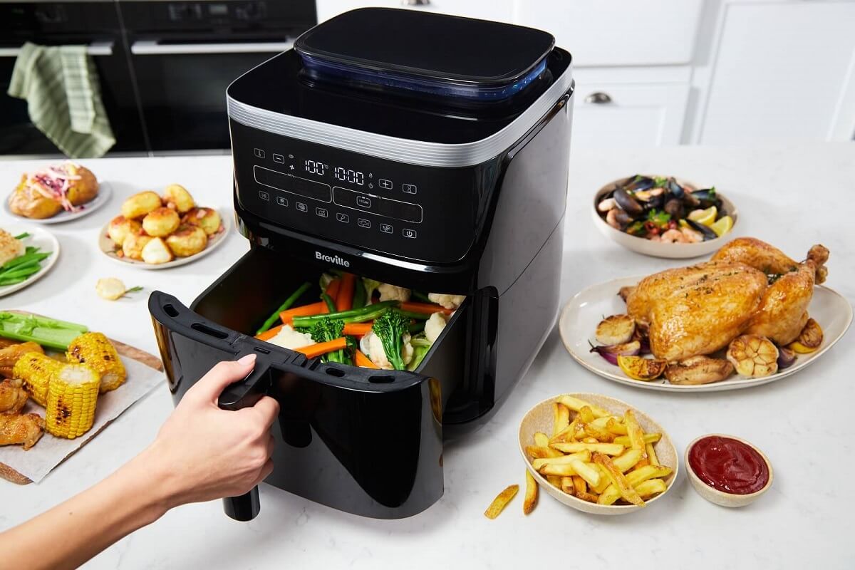 Frytkownica beztłuszczowa Airfryer Breville Halo Steam Digital VDF133X łączy gotowanie na parze i smażenie powietrzem dzięki technologii SteamFry, zapewniając chrupiące i soczyste potrawy. Oszczędza 50% energii, ma 6 programów i pojemny zbiornik na wodę (1,4 l) na 90 minut gotowania na parze. Intuicyjny panel LED, wysoka moc (1700 W) i łatwe czyszczenie sprawiają, że to idealne urządzenie do zdrowszego gotowania.